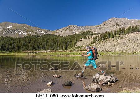 Hispanic hiker climbing on rocks in lake View Large Photo Image Stock Image - Hispanic hiker climbing on rocks in lake. Fotosearch