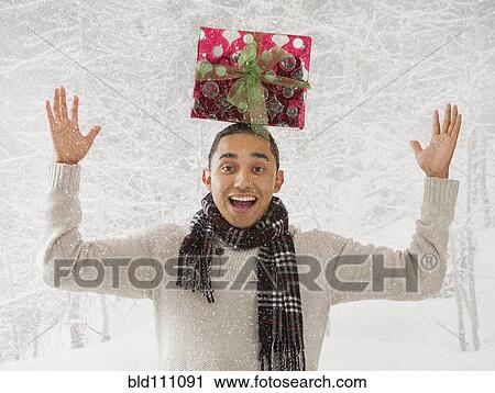 Hispanic man balancing present on head in snow View Large Photo Image Stock Image - Hispanic man balancing present on head in snow. Fotosearch