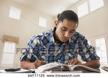 Stock Photography - Hispanic man studying at desk. Fotosearch