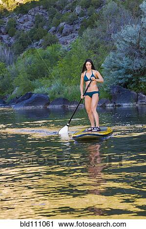 Hispanic woman riding paddle board View Large Photo Image Stock Image - Hispanic woman riding paddle board. Fotosearch
