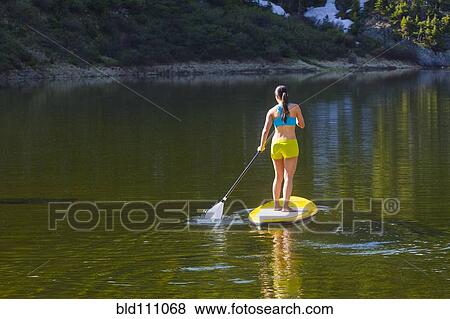 Hispanic woman riding paddle board View Large Photo Image Stock Photo - Hispanic woman riding paddle board. Fotosearch