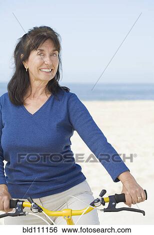 Stock Photograph - Hispanic woman sitting on bicycle. Fotosearch