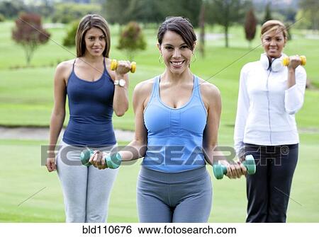 Hispanic women lifting hand weights together View Large Photo Image Stock Photograph - Hispanic women lifting hand weights together. Fotosearch