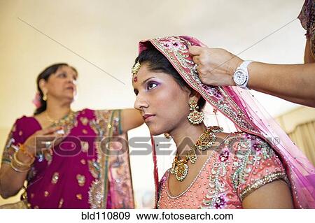 Stock Photo - Indian bride wearing colorful fabrics and jewelry. Fotosearch