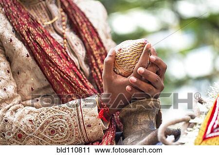Stock Image - Indian groom holding coconut. Fotosearch