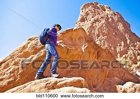Stock Image - Japanese woman hiking on rocks. Fotosearch