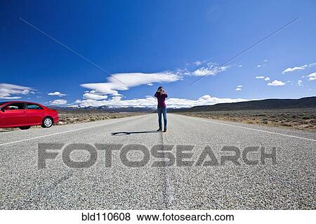 Stock Photo - Japanese woman using binoculars on road trip. Fotosearch