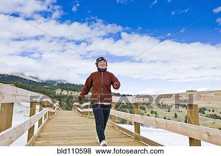 Japanese woman walking across wooden bridge View Large Photo Image Stock Photo - Japanese woman walking across wooden bridge. Fotosearch