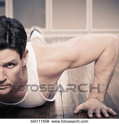 Stock Photo - Man doing push ups indoors. Fotosearch