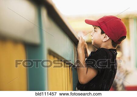 Mixed race boy climbing on banister View Large Photo Image Stock Photo - Mixed race boy climbing on banister. Fotosearch