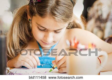 Mixed race girl coloring at desk View Large Photo Image Stock Photo - Mixed race girl coloring at desk. Fotosearch