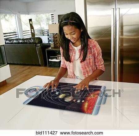Stock Photo - Mixed race girl playing on computer in table. Fotosearch