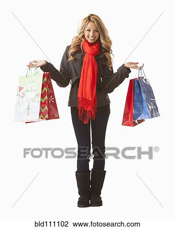 Stock Image - Mixed race woman holding shopping bags. Fotosearch