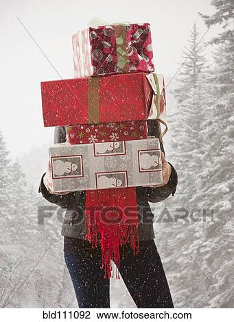 Mixed race woman holding stack of presents in snow View Large Photo Image Stock Image - Mixed race woman holding stack of presents in snow. Fotosearch