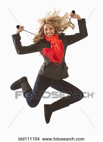 Picture - Mixed race woman jumping for joy. Fotosearch