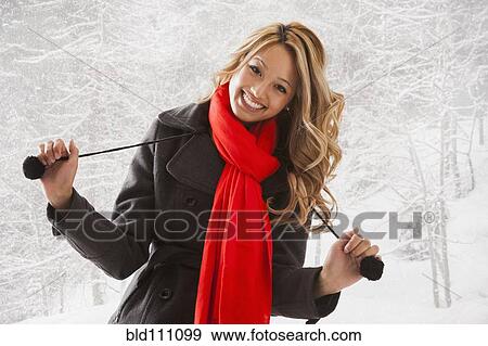 Stock Photo - Mixed race woman smiling in snow. Fotosearch
