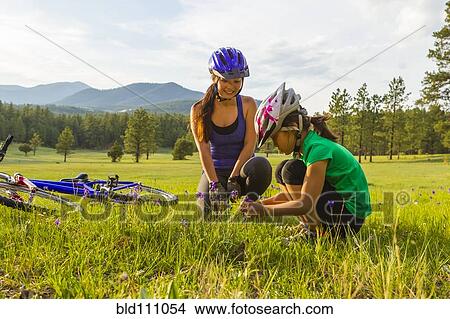 Picture - Mother and daughter sitting in meadow. Fotosearch