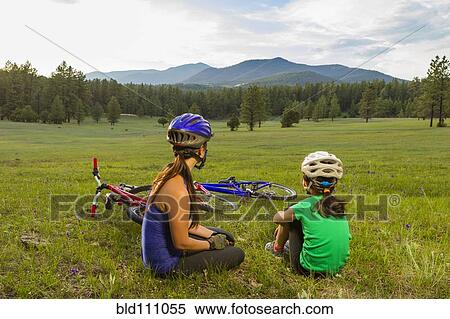Stock Photography - Mother and daughter sitting in meadow. Fotosearch