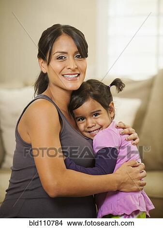 Pregnant Hispanic mother hugging daughter View Large Photo Image Picture - Pregnant Hispanic mother hugging daughter. Fotosearch