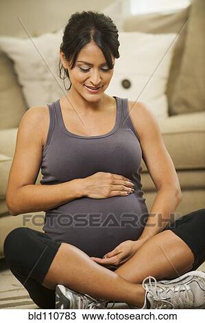 Pregnant Hispanic woman holding her belly View Large Photo Image Stock Image - Pregnant Hispanic woman holding her belly. Fotosearch