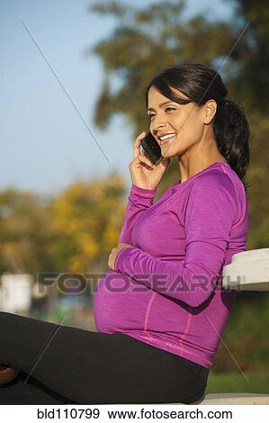 Pregnant Hispanic woman talking on cell phone View Large Photo Image Stock Photo - Pregnant Hispanic woman talking on cell phone. Fotosearch
