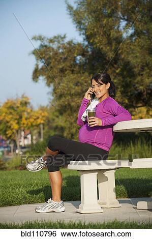 Pregnant Hispanic woman talking on cell phone View Large Photo Image Stock Photograph - Pregnant Hispanic woman talking on cell phone. Fotosearch