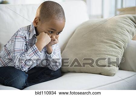 Schmollendes, afrikanischer amerikanischer junge, sitzen sofa Bild