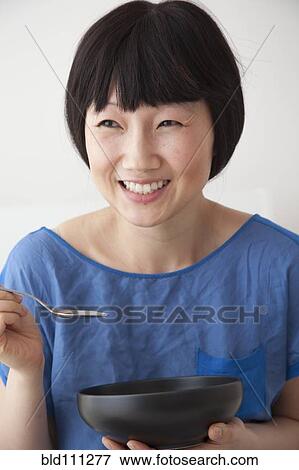 Stock Photo - Smiling Chinese woman eating. Fotosearch