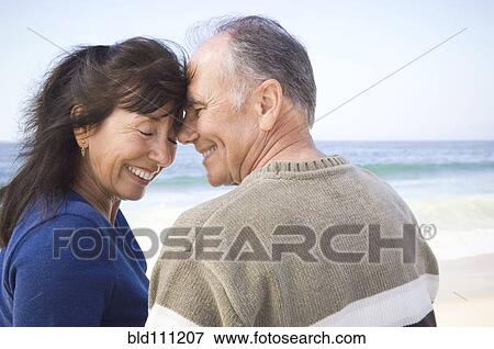 Stock Photo - Smiling couple hugging on beach. Fotosearch
