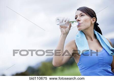 Stock Photography - Woman drinking water after exercise. Fotosearch