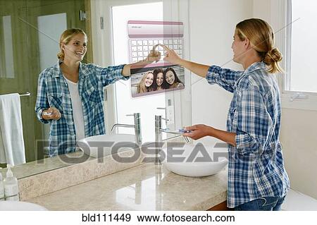Stock Photo - Woman using computer in mirror. Fotosearch