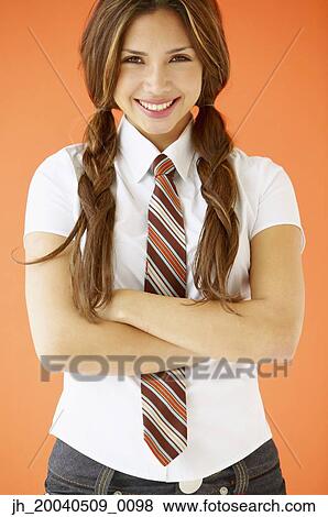 Portrait of a young woman standing with her arms folded View Large Photo Image Stock Photo - Portrait of a young woman standing with her arms folded. Fotosearch