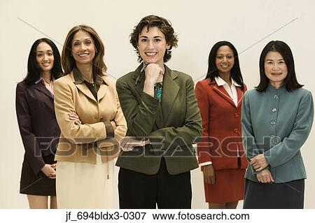 Stock Photo - Group of young businesswomen standing together looking at camera smiling. Fotosearch