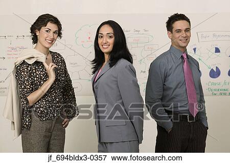 Stock Photo - Two young businesswomen looking at camera smiling. Fotosearch