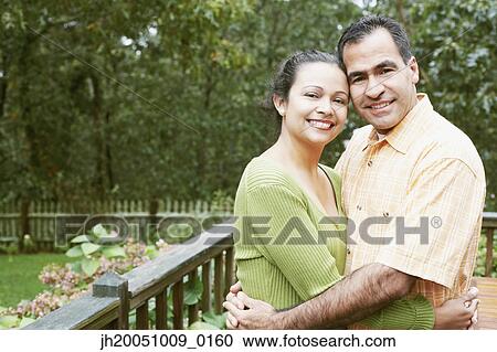 Couple hugging in their backyard View Large Photo Image Stock Image - Couple hugging in their backyard. Fotosearch