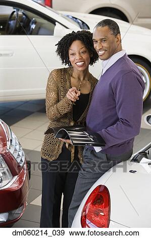 Couple picking out a car to buy View Large Photo Image Stock Photo - Couple picking out a car to buy. Fotosearch