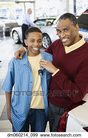 Stock Photo - Father and son at a car dealership. Fotosearch