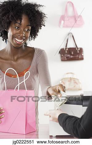 Female employee ringing a customer up at the cash register View Large Photo Image Stock Image - Female employee ringing a customer up at the cash register. Fotosearch