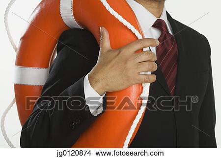 Picture - Close up of businessman holding life preserver. Fotosearch