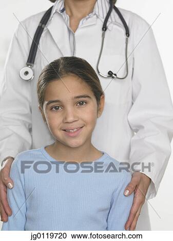 Stock Image - Young girl and female doctor posing for the camera. Fotosearch