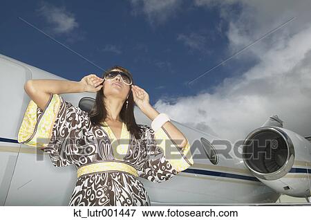 Woman standing in front of small jet, Nobato, California, United States View Large Photo Image Stock Photo - Woman standing in front of small jet, Nobato, California, United States. Fotosearch