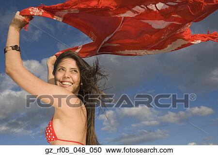 Young woman holding shawl over her head in the wind View Large Photo Image Stock Image - Young woman holding shawl over her head in the wind. Fotosearch