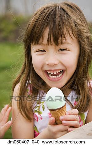 Young Asian girl eating ice cream cone View Large Photo Image Stock Image - Young Asian girl eating ice cream cone. Fotosearch