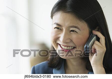 Stock Image - Middle aged businesswoman talking on her cell phone. Fotosearch