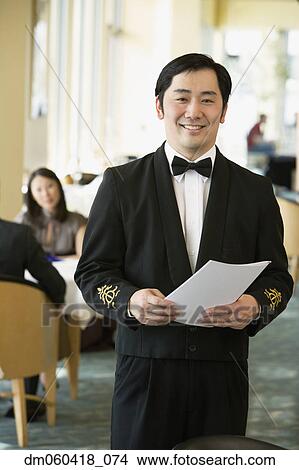 Picture - Asian male waiter at upscale restaurant. Fotosearch