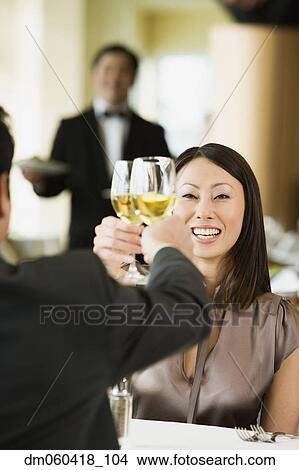 Picture - Asian woman toasting at restaurant. Fotosearch
