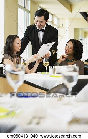 Stock Image - Businesswoman ordering meal in restaurant. Fotosearch