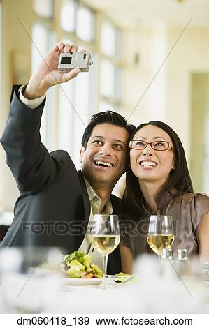 Couple taking their own photograph with digital camera View Large Photo Image Stock Photo - Couple taking their own photograph with digital camera. Fotosearch