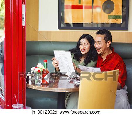 Mid adult couple sitting in a restaurant View Large Photo Image Stock Photography - Mid adult couple sitting in a restaurant. Fotosearch