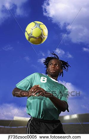 Stock Photography - Male soccer player headering the ball. Fotosearch